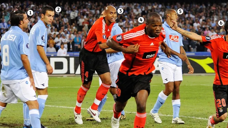 Cầu thủ Benfica với sự quyết tâm chạy bóng qua cầu thủ Napoli trên sân cỏ Cầu thủ Benfica với sự quyết tâm chạy bóng qua cầu thủ Napoli trên sân cỏ